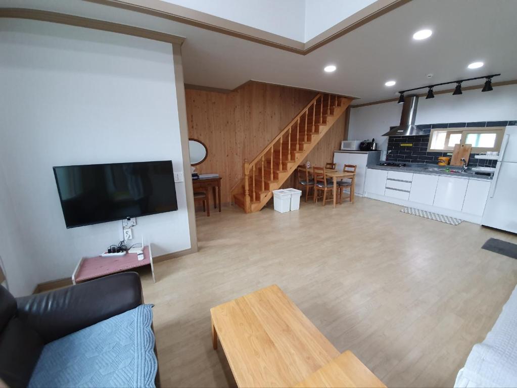 江陵市Gyeongpodae Darakbang的客厅配有沙发和桌子