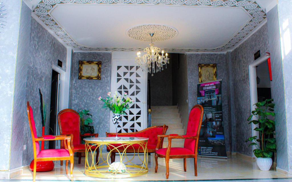 塔巴卡Résidence Les Camélias的一间用餐室,配有红色的椅子和桌子
