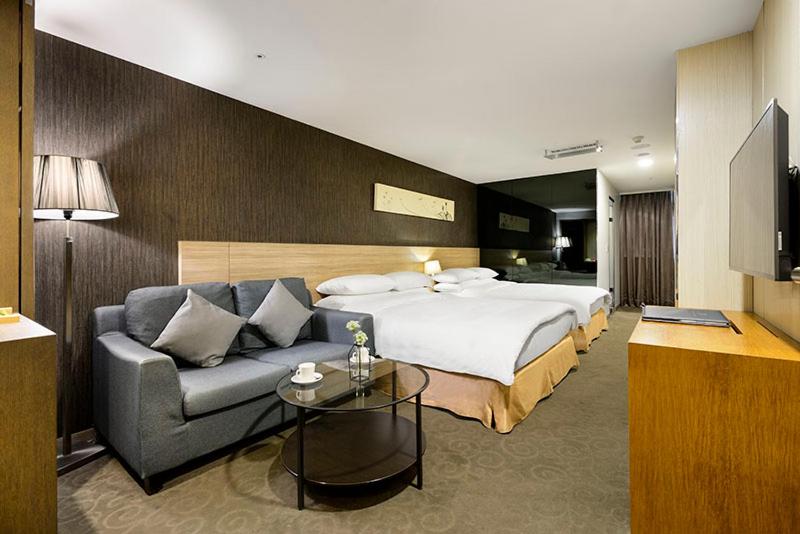 台中市碧根逢甲酒店的酒店客房,配有床和沙发