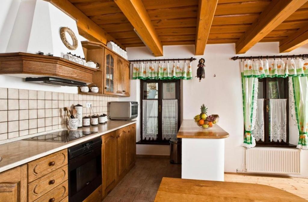 米库洛夫VIP MiKU apartman 2的厨房配有木制橱柜和绿色窗帘