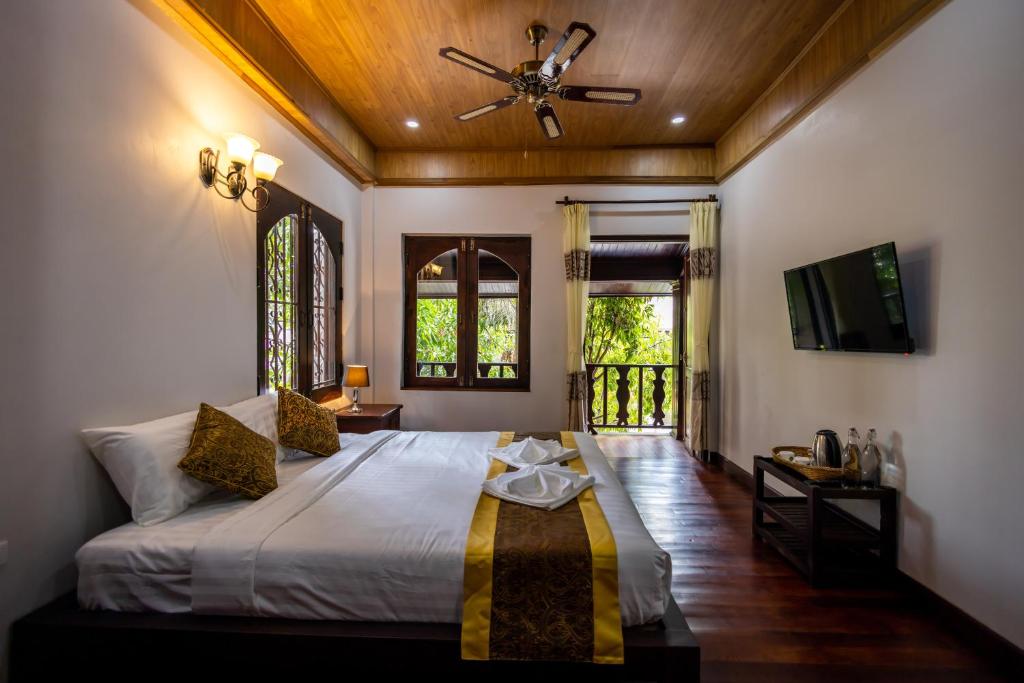 琅勃拉邦Villa Mira Heritage的一间卧室配有一张床和吊扇