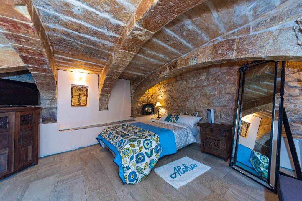 瓦莱塔Valletta Traditional Townhouse的一间卧室设有一张床和石墙