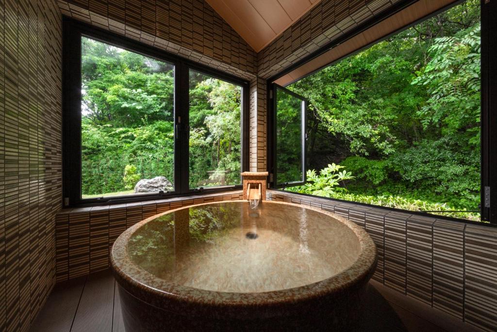 忍野村八海 木花館的带窗户的客房内的大浴缸
