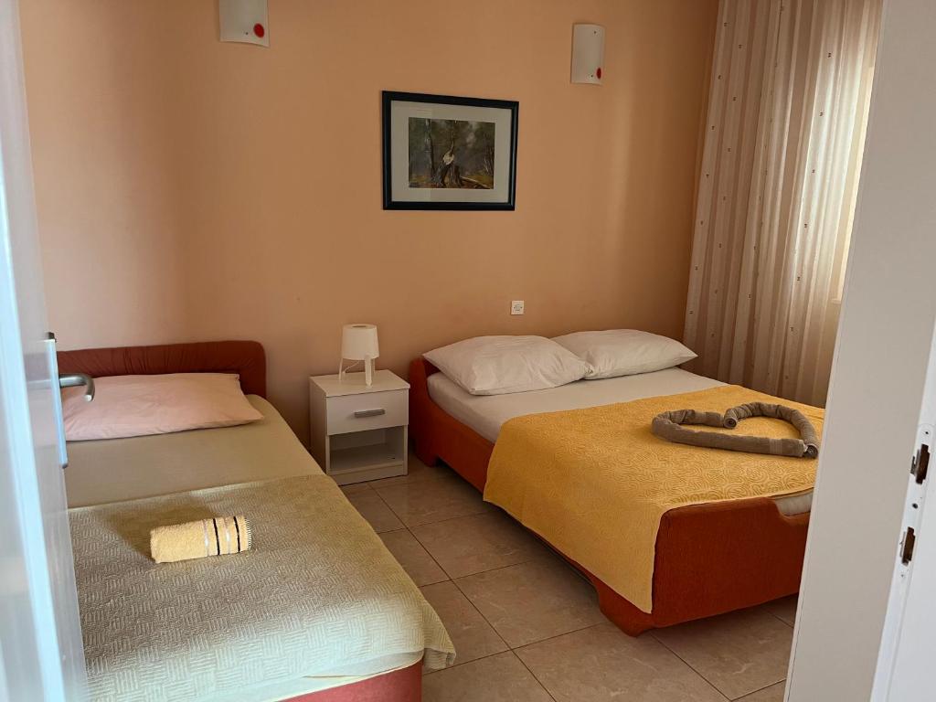 塞维德Apartments Pralija的酒店客房设有两张床,墙上挂着一张照片。