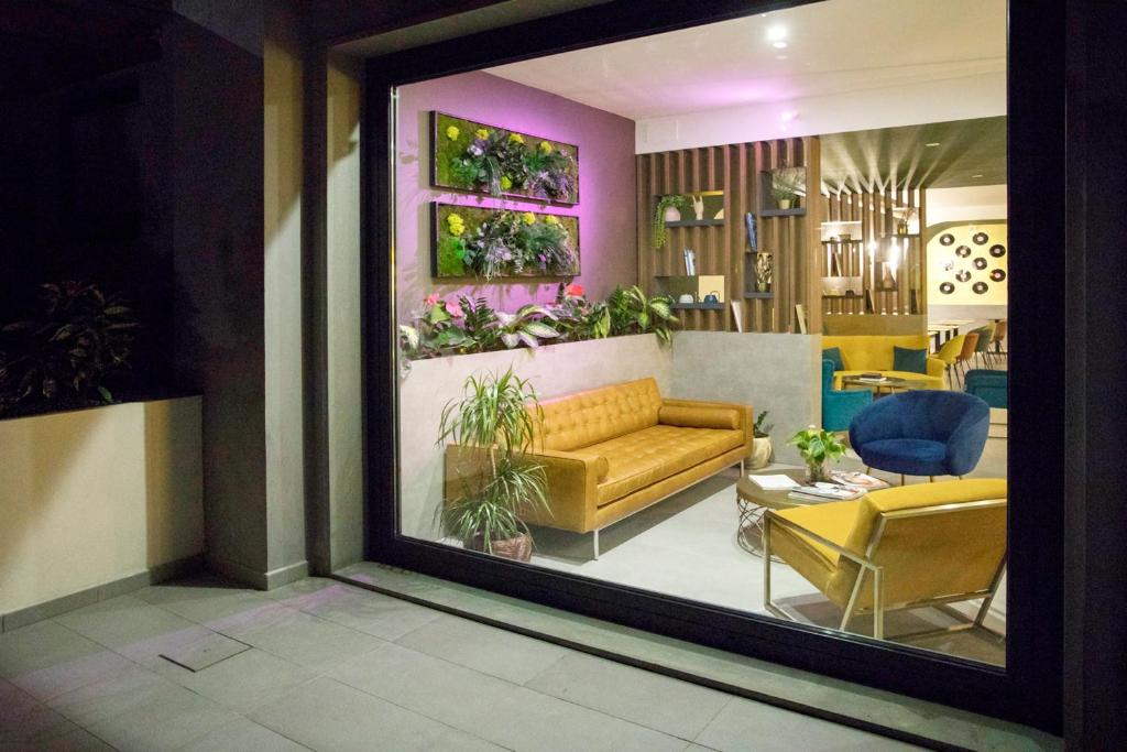 特拉诺瓦-布拉乔利尼Moody smart & comfy Hotel的享有带沙发和椅子的客厅的景色