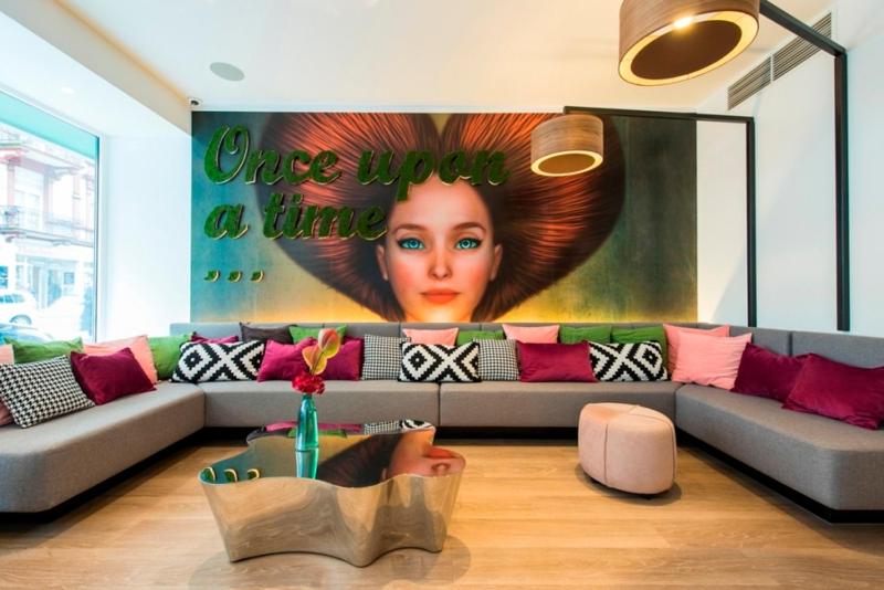 美因河畔法兰克福大使酒店的客厅里设有一张沙发和一张女用海报