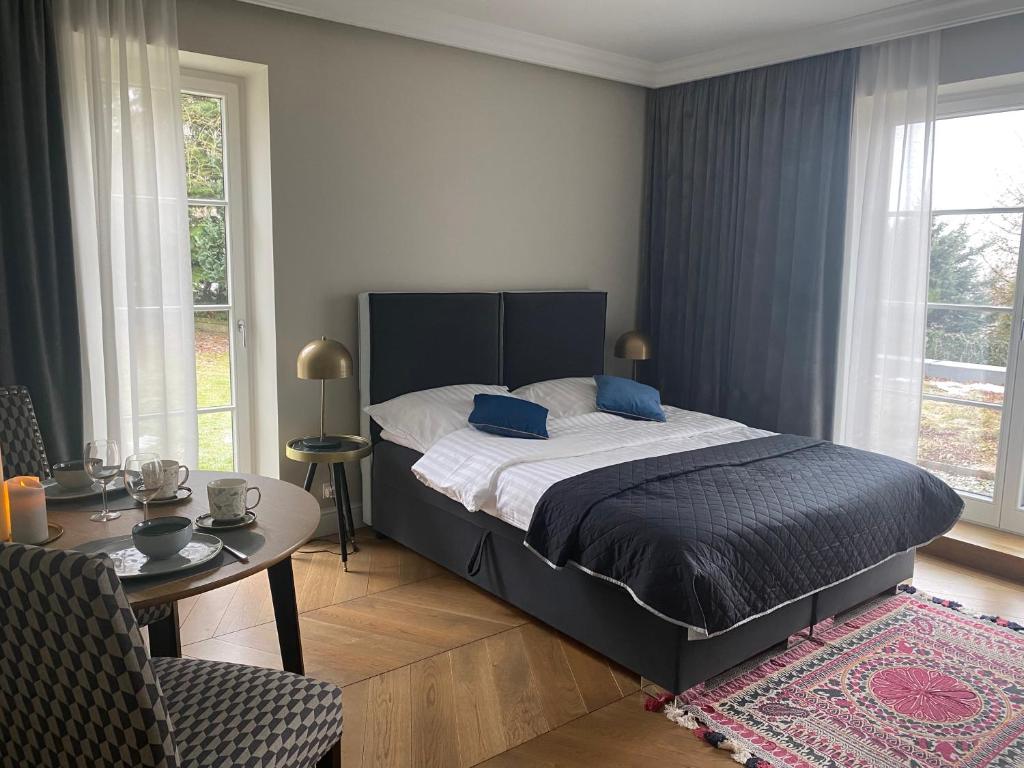 BaliceKraków Green Hill Luxury Apartment的卧室配有床、桌子和窗户。