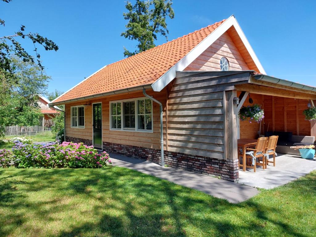 Hazerswoude-RijndijkLodges near the Rhine - Sustainable Residence的一座带庭院和草坪的小房子