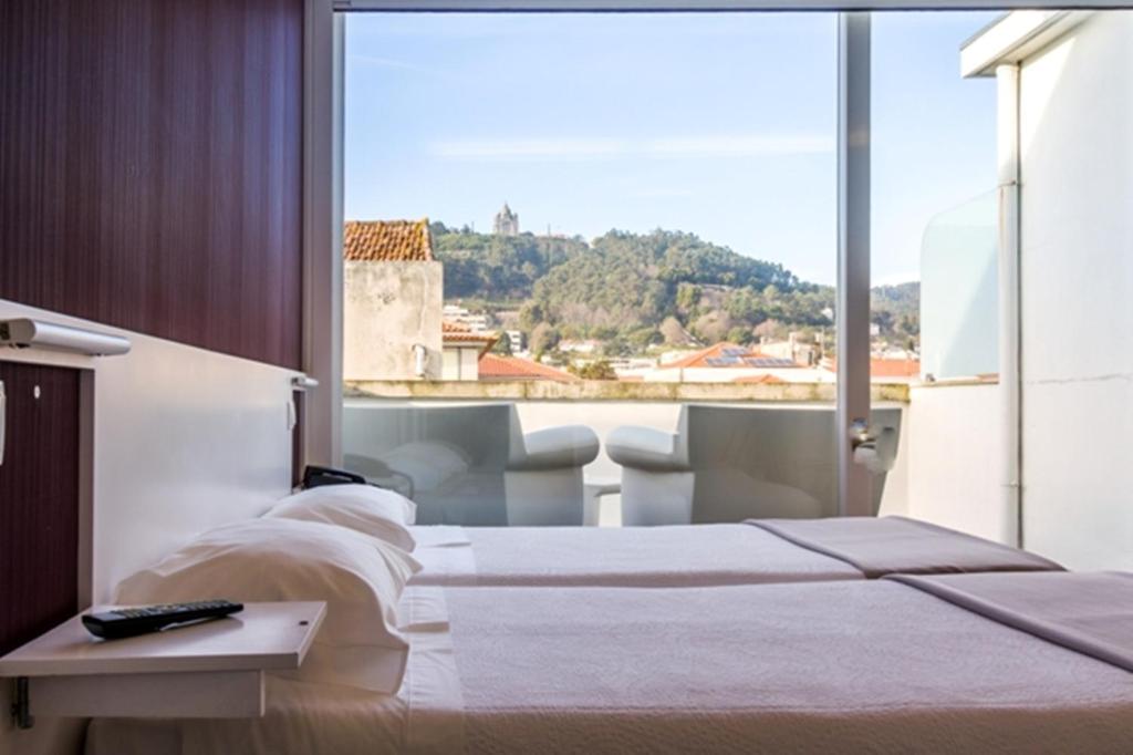 维亚纳堡拉兰热拉酒店的一间卧室设有两张床和大窗户