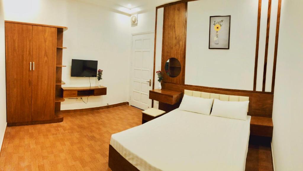 海防Đức Tuân 2 Motel的卧室配有白色的床和电视。