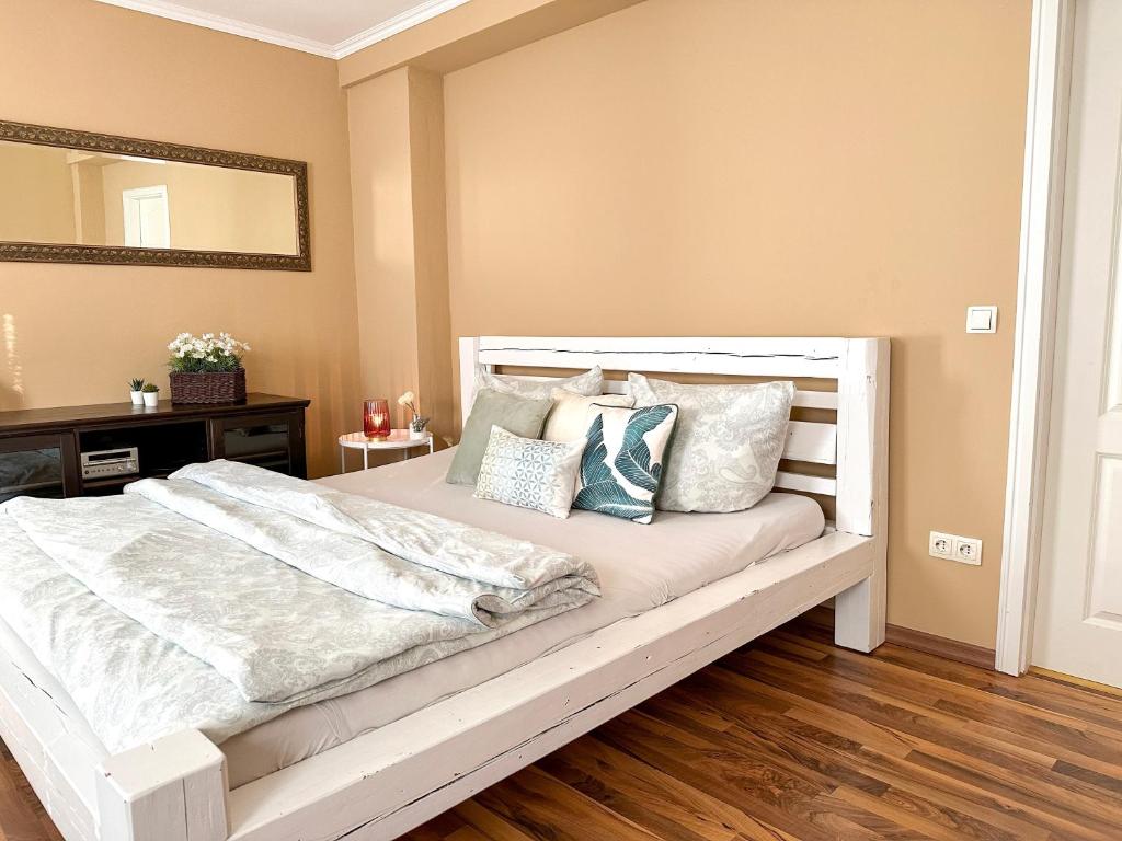 德累斯顿Apartement am Schloss Pillnitz的卧室配有带枕头和镜子的白色床
