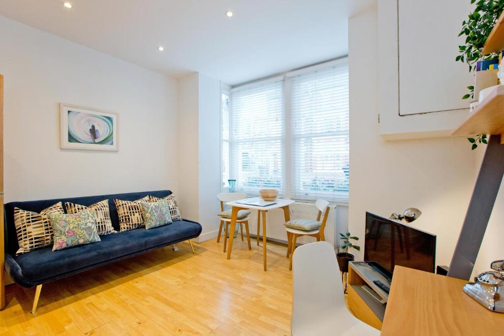 伦敦Calabria 2 - Cosy apartment的客厅配有沙发和桌子