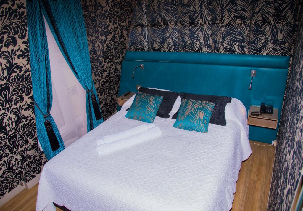巴黎Hôtel du Mont Blanc的一张蓝色的床,上面有两个枕头