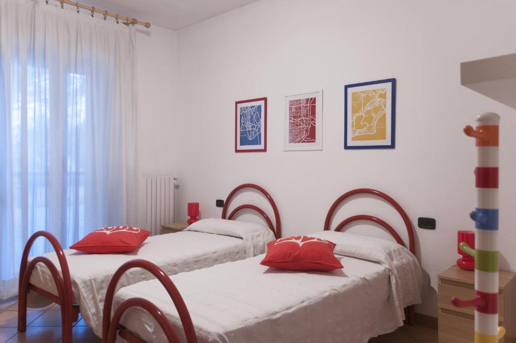 奥利维托拉里奥Ca' Eli 2的白色客房的两张床,配有红色枕头