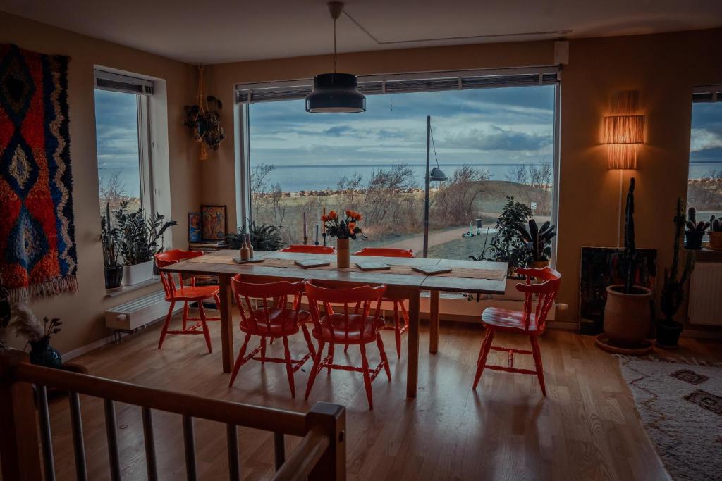 马尔默Privatsvit, havsnära och centralt的一间带桌椅和大窗户的用餐室