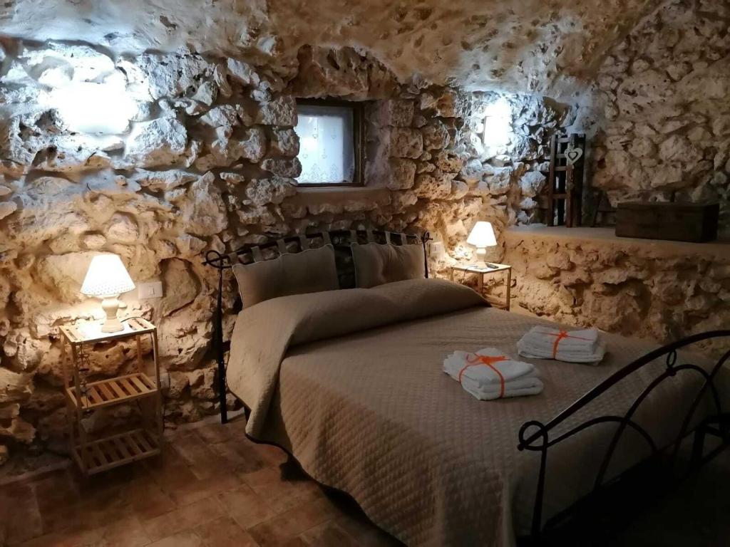 圣多纳托瓦尔迪科米诺Tenuta Castelli的卧室配有一张石墙床