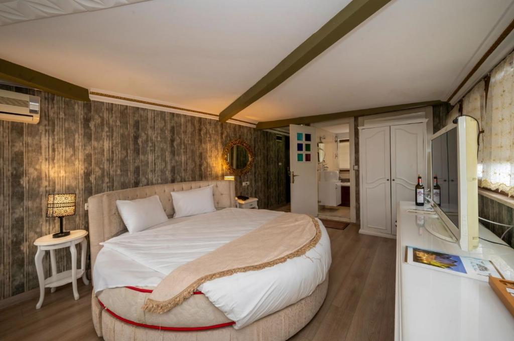 伊斯坦布尔Fuat Bey Palace Hotel & Suites的一间带大床的卧室和一间浴室