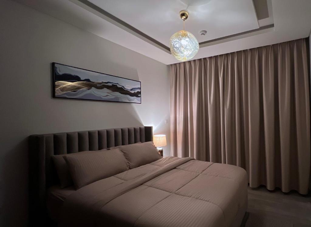 马斯喀特Luxury apartment in Muscat Hills的一间卧室配有一张床和一个吊灯