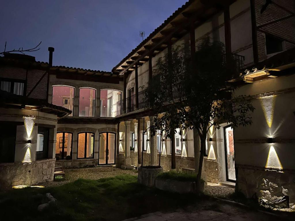 阿尔卡拉德荷那利斯Casa de los Mendoza - Casa Solariega en el casco histórico的一座老建筑,院子里有一棵树