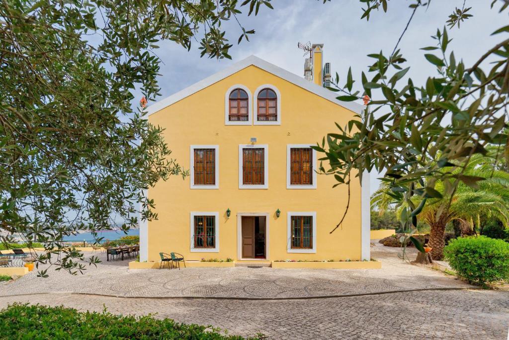 塞图巴尔Villa Casal Assis的白色屋顶的黄色房子