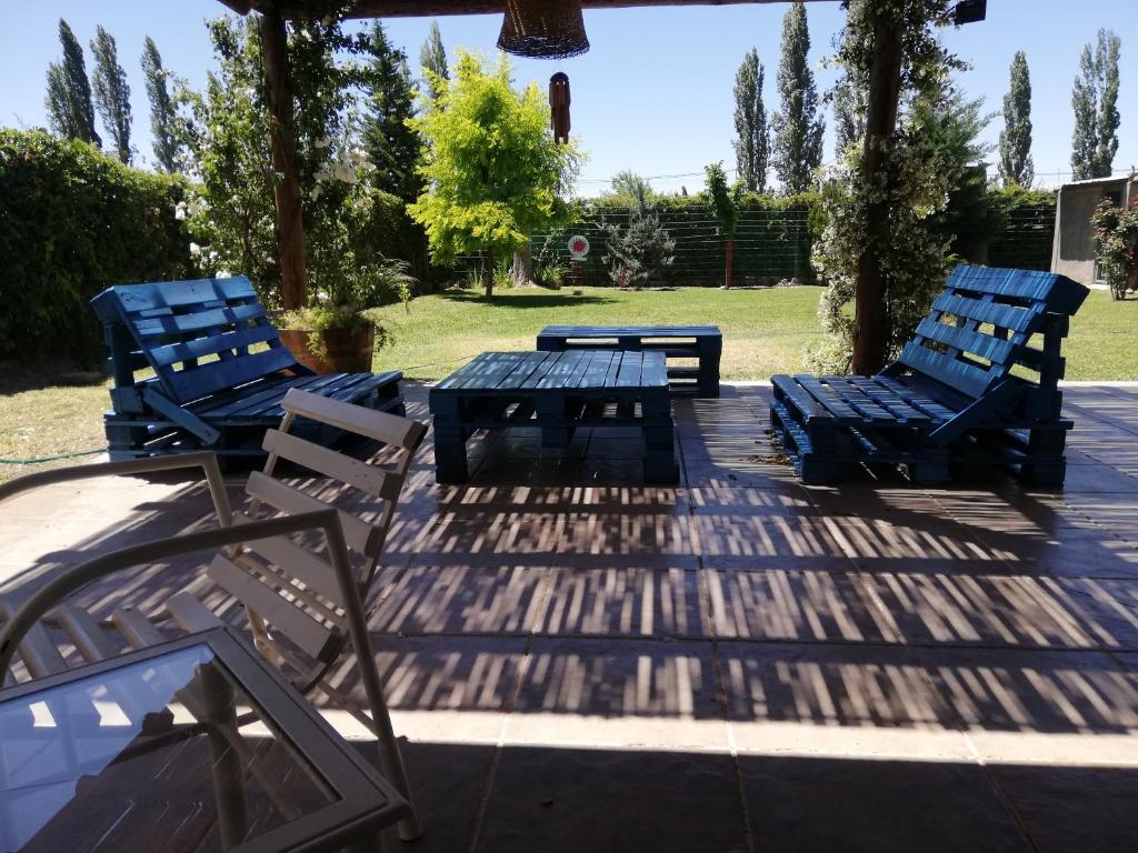 卢汉德库约El descanso, zona de bodegas的庭院里设有3把蓝色椅子和1张野餐桌