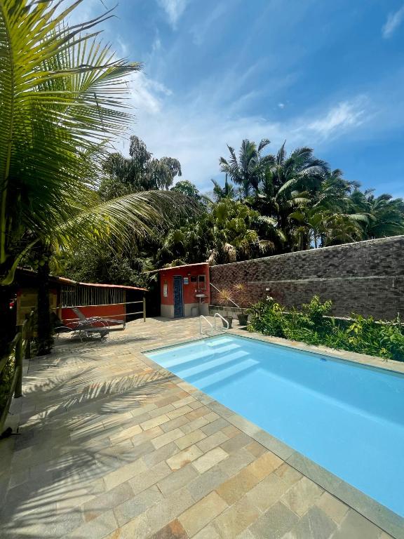 坎布里Aldeia de Camburi的一座带砖墙的庭院内的游泳池