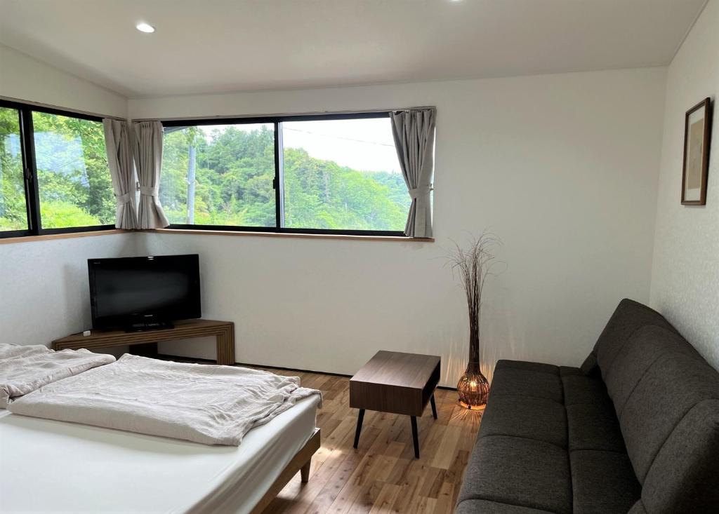 镰仓市Open House Sakurasakura - Kamakurayama - - Vacation STAY 14047的一间卧室配有一张床、一张沙发和一台电视