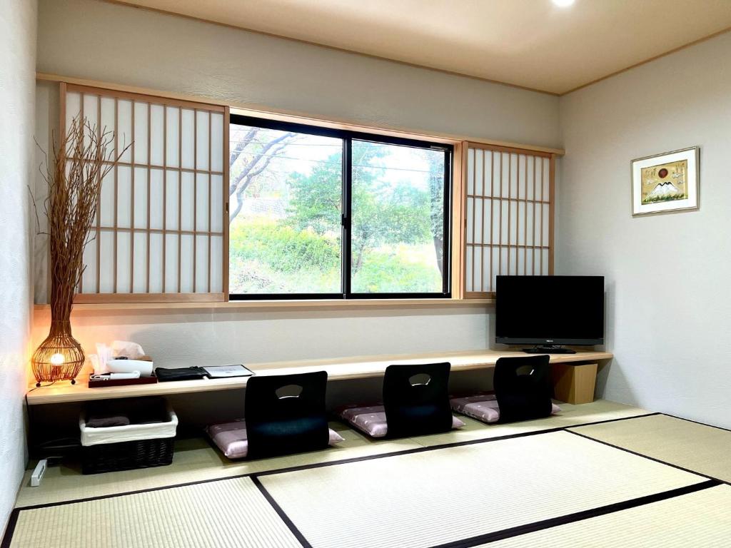 镰仓市Open House Sakurasakura - Kamakurayama - - Vacation STAY 14049的客厅配有两把椅子和电视