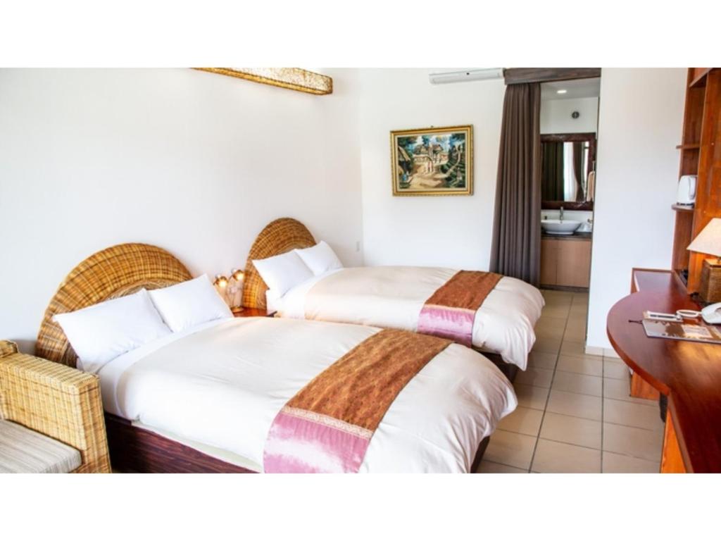 MitsuneHachijojima Hotel Resort Sea Pillows - Vacation STAY 53160v的酒店客房配有两张床和一张书桌