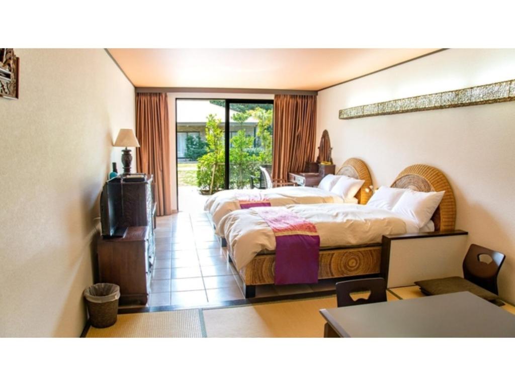 MitsuneHachijojima Hotel Resort Sea Pillows - Vacation STAY 53191v的酒店客房设有两张床和电视。