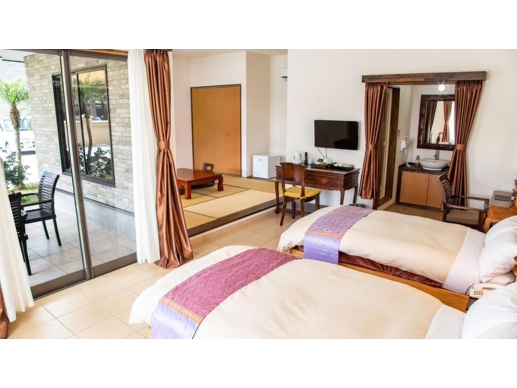 MitsuneHachijojima Hotel Resort Sea Pillows - Vacation STAY 53308v的酒店客房设有两张床和一个阳台。