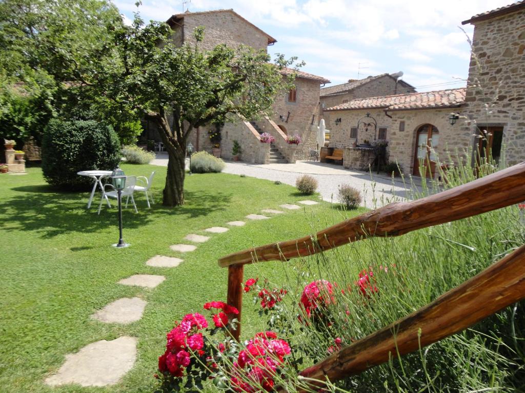 科尔托纳卡萨莱兰蒂科卡洛酒店的草上种着桌子和鲜花的花园