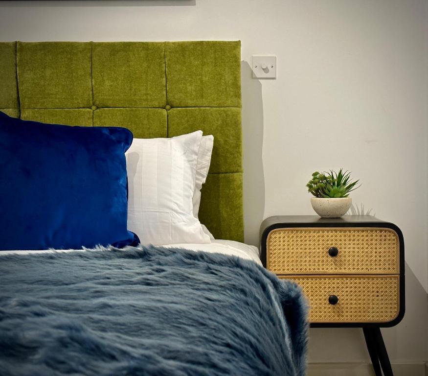NailseaServiced Apartments Nailsea的卧室配有一张床,床头柜上种植了植物