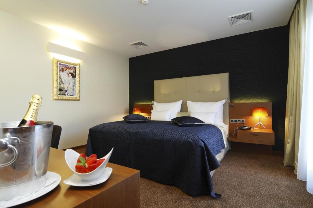 尼特拉米卡多酒店的酒店客房,配有一张床和一瓶葡萄酒