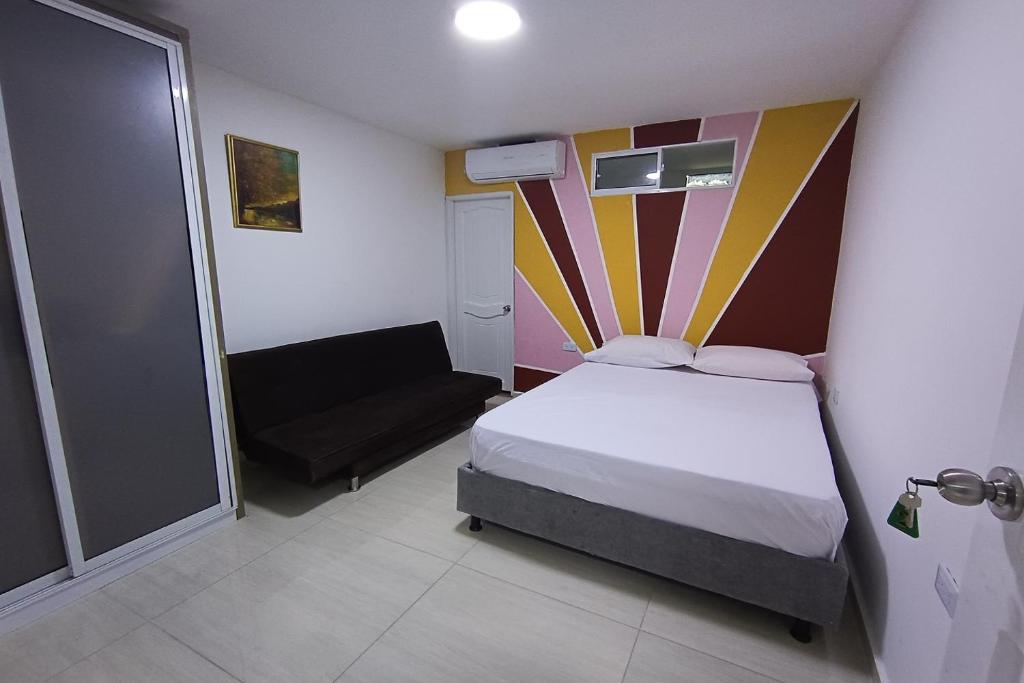 巴兰基亚Ayenda Brisas del Rio的一间小卧室,配有一张床和一把椅子