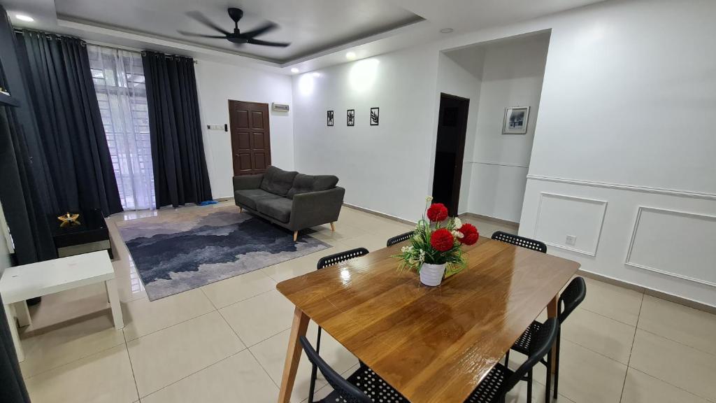 樟仑D'Lisha Homestay Changlun/Bukit Kayu Hitam/Sintok的客厅配有桌子和椅子