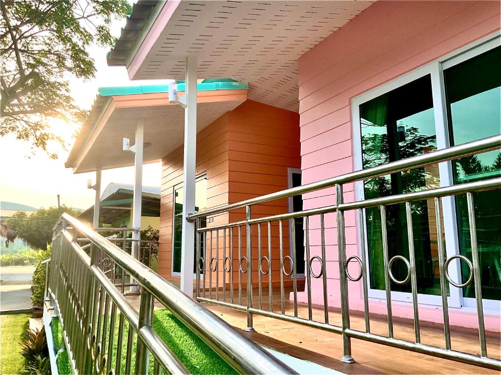 北榄Ban Ing Suan的门廊上带栏杆的粉红色房子