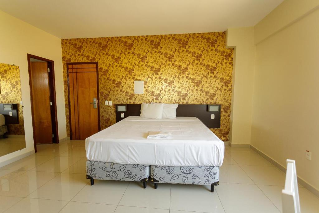 帕劳阿佩巴斯Atrium Express Hotels的一间卧室配有一张黄色墙壁的床