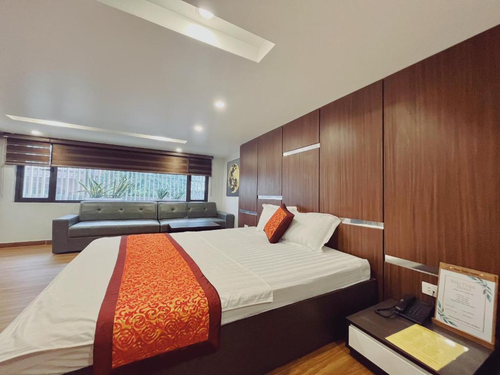 海防DT Hotel Hai Phong的一间卧室配有一张大床和一张沙发