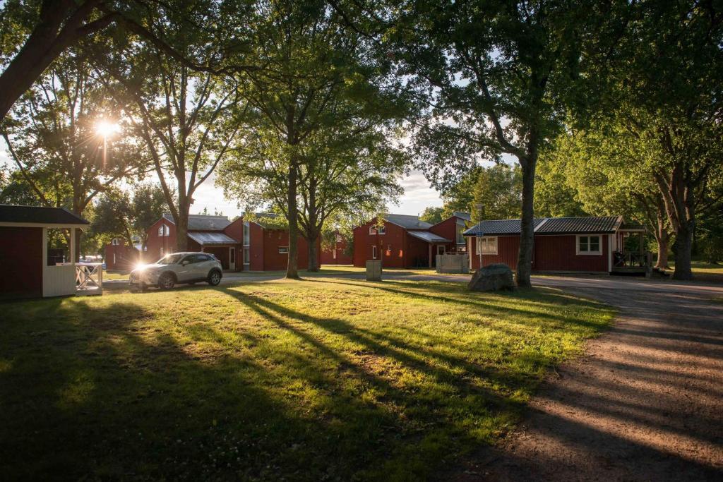 韦斯特罗斯First Camp Västerås-Mälaren的停在住宅街道的草地上的汽车