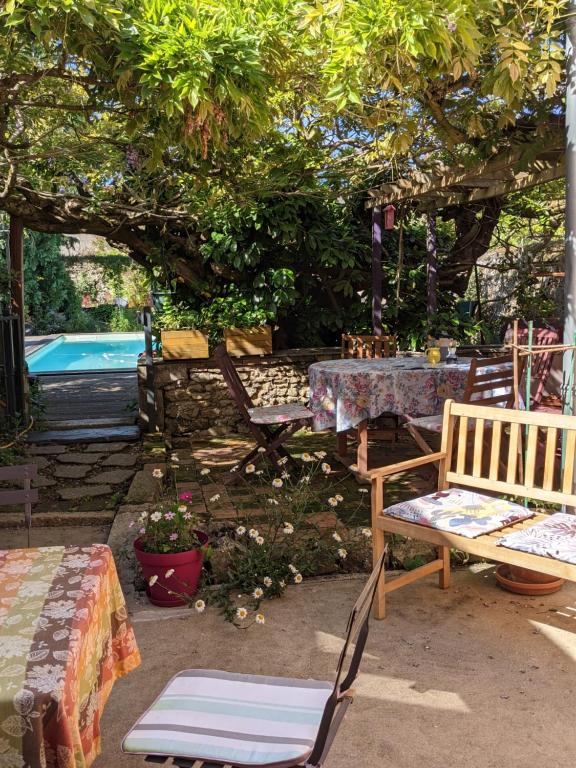 拉弗雷切Chambres d'hôtes La Charmante的庭院设有桌椅、桌子和游泳池。