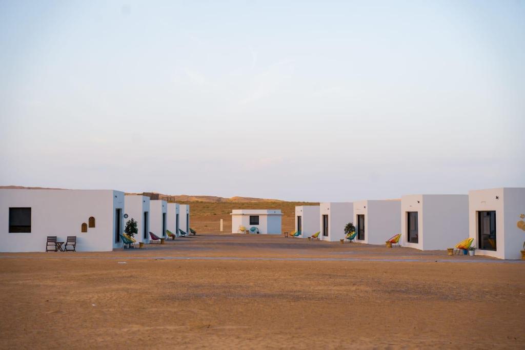 Shāhiq游猎沙漠营地度假酒店的沙漠中一排白色的建筑