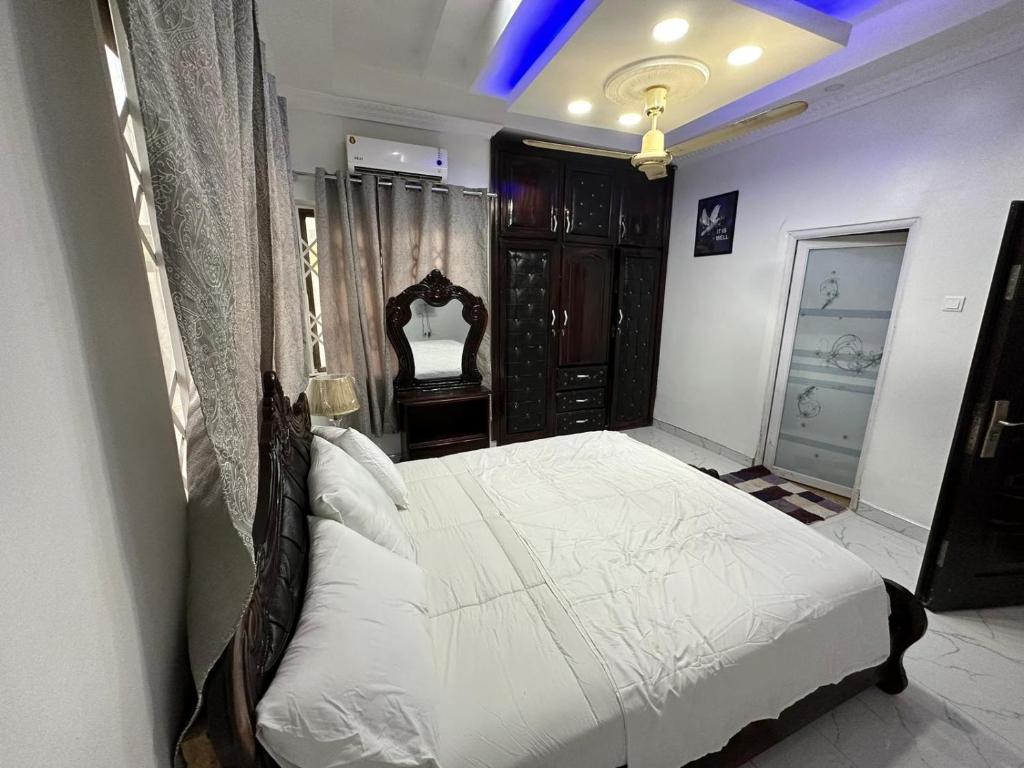 库马西BENJI'S VILLA的一间卧室配有一张带白色床单的大床