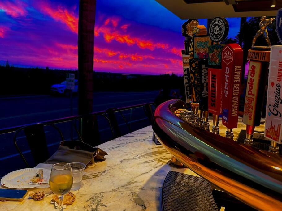 圣地亚哥Del Mar townhouse by Torrey Pines Beach的阳台上的一张桌子,上面放着一杯葡萄酒,还可欣赏到日落美景