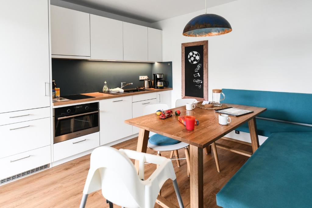 腓特烈港EntdeckerFERIEN am Bodensee的厨房配有木桌和蓝色沙发。
