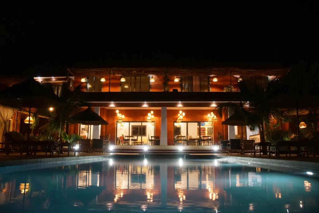恩加帕鲁Maison de clara的一座游泳池,在晚上在建筑物前