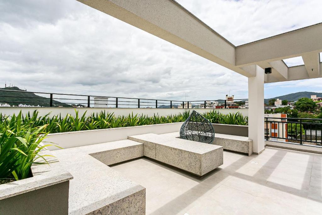 弗洛里亚诺波利斯Apartamentos completos ao lado da UFSC - NAVONA的阳台的天井设有长凳