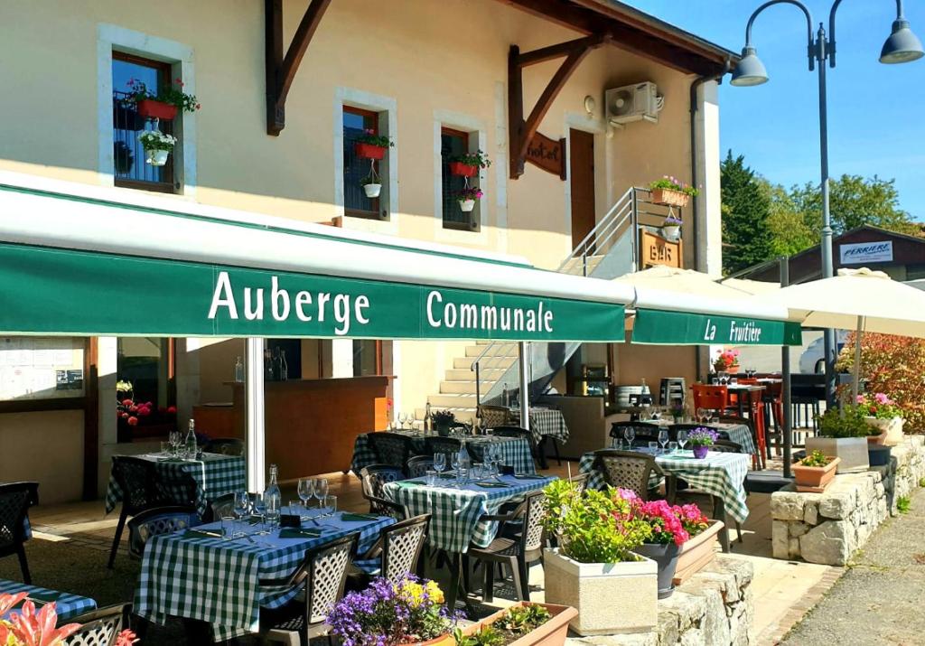 PéronAuberge Communale de la Fruitière的大楼前设有桌椅的餐厅