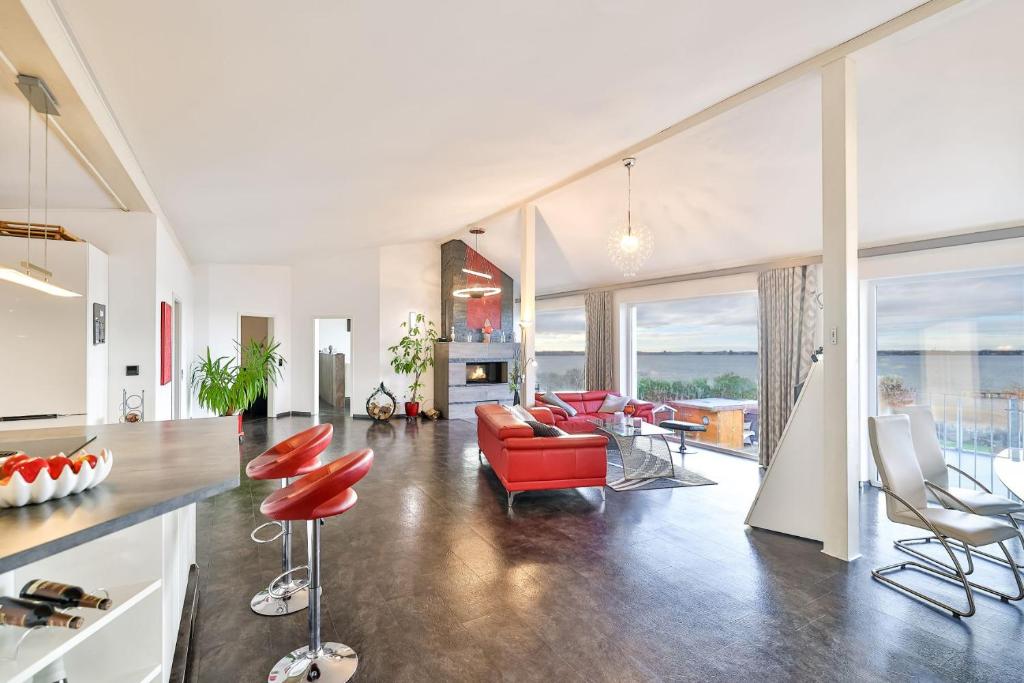 阿尔特费尔Panoramalodge Rügen的客厅配有红色的沙发和椅子