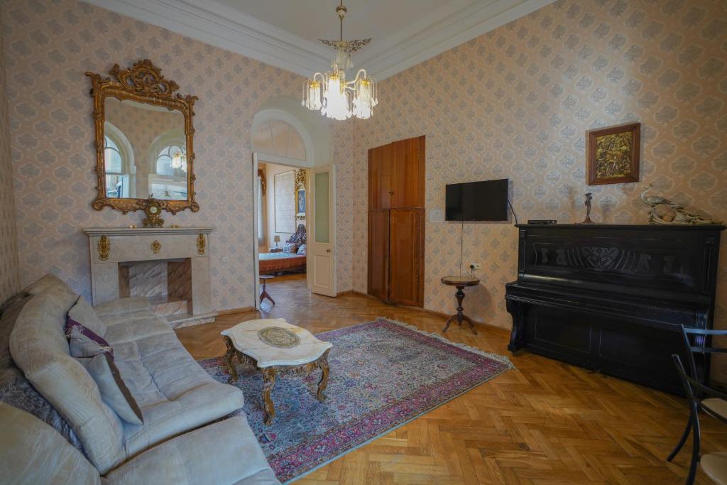 第比利斯Leon Rooms的客厅配有沙发、镜子和钢琴